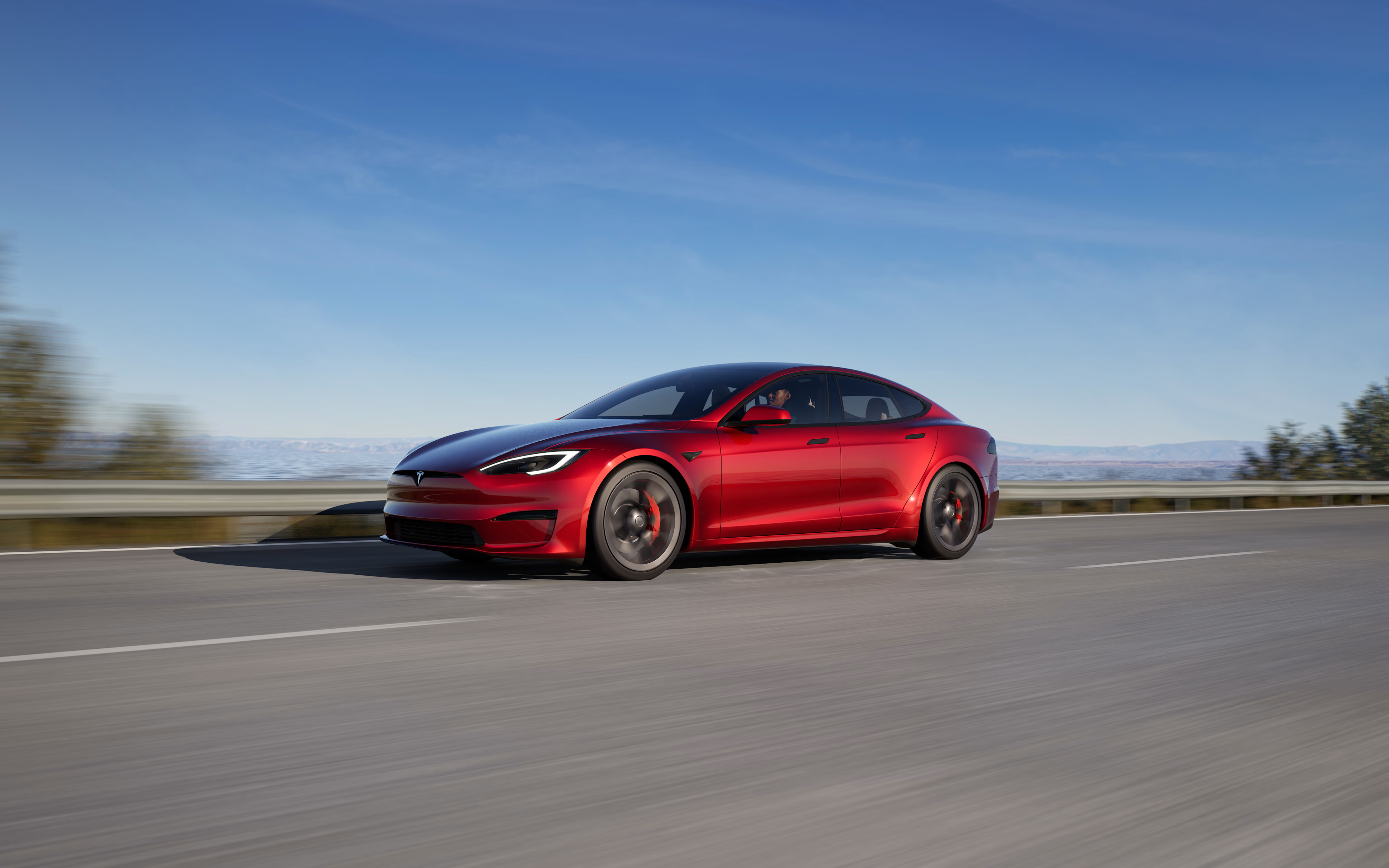 Solid black Model S accelerating on an elevated highway